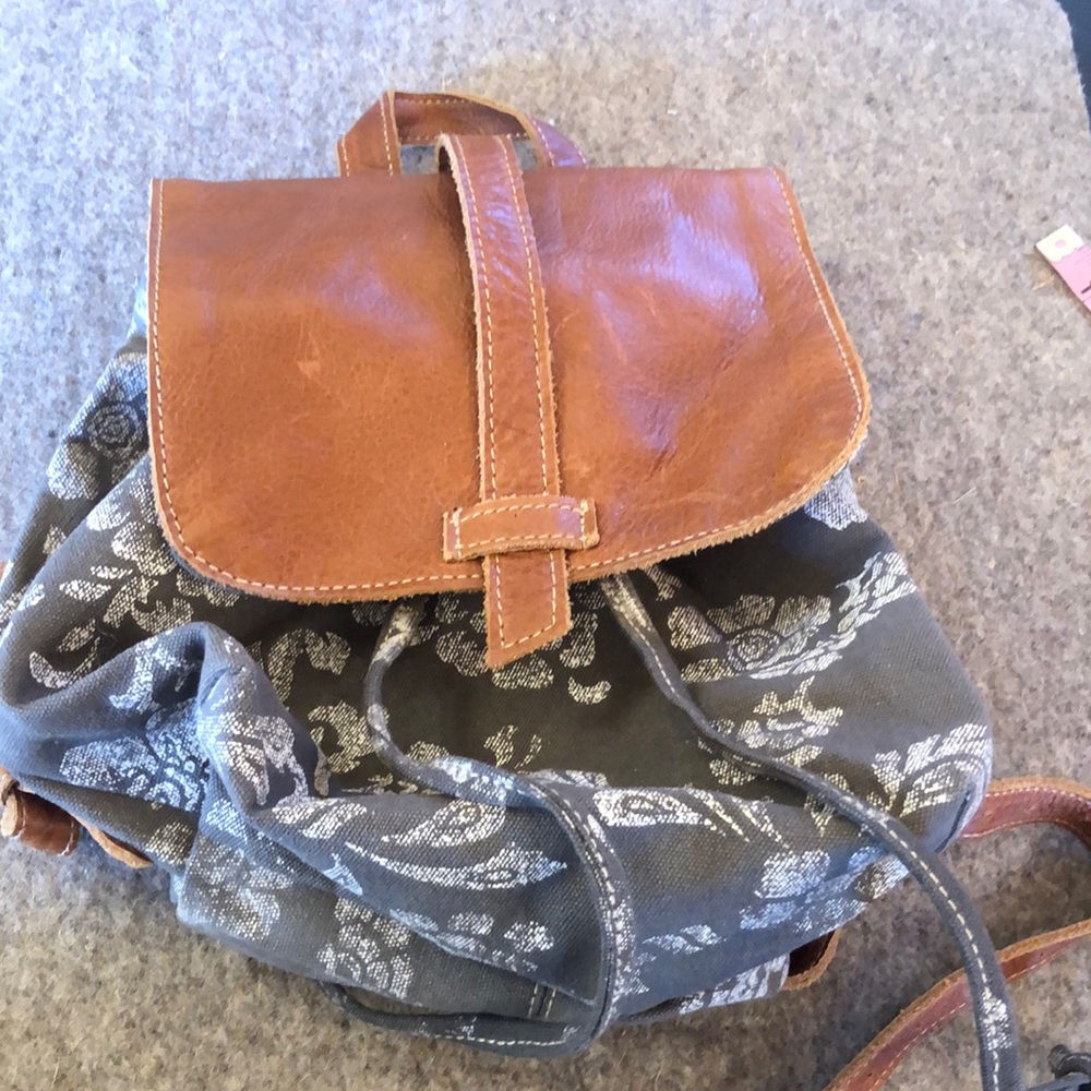Grey floral backpack with leather adjustable straps.